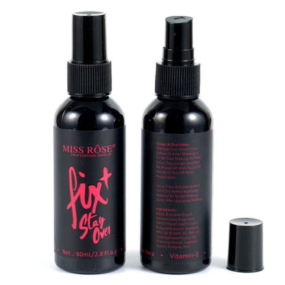 Two bottles of Miss Rose Fix+ Stay Over Fixer with spray nozzles, vitamin E listed as an ingredient, and a small container beside them.